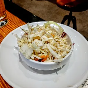 In house made coleslaw. Lovely and tart. Not mayo based, but not very sweet.