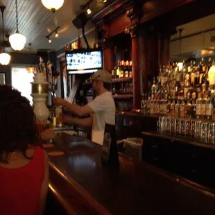 a bartender pouring a drink at the bar