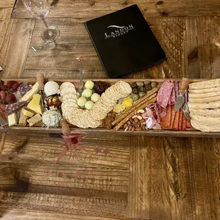 a platter of cheese, crackers, and meats