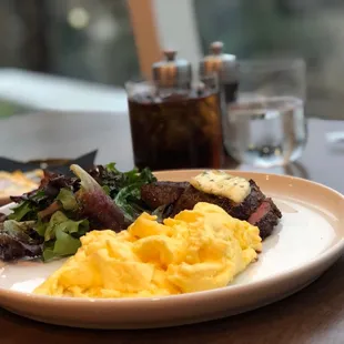 Petite tenderloin and eggs with mixed green salad for breakfast