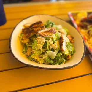 a plate of salad and a pizza