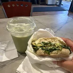 Iced matcha latte with egg, spinach and Swiss breakfast sandwich