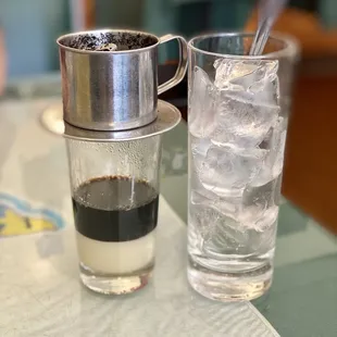 a glass of water and a cup of coffee on a table