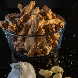 a bowl of garlic and a clove of garlic