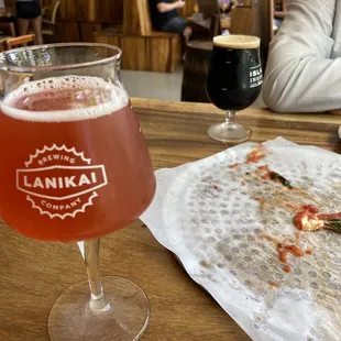 a half eaten pizza and a glass of beer