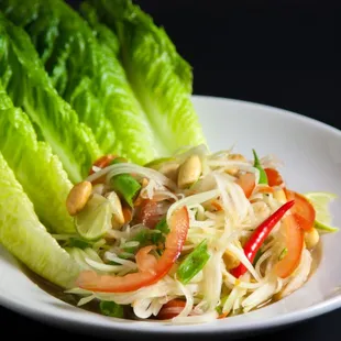 Papaya Salad - Fresh shredded green papaya with, carrots, tomatoes, green beans, peanuts, tamarind lime sauce.  Spicy level from 0-10.  GF!