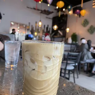 a glass of iced coffee on a table