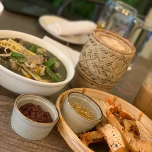 a bowl of soup, a bowl of bread, and a bowl of soup on a table