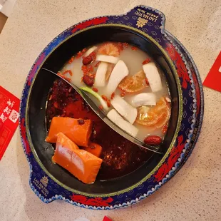 a bowl of soup with shrimp and carrots
