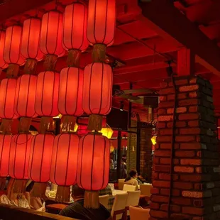A wall of traditional red lanterns on one side of the outdoor dining area
