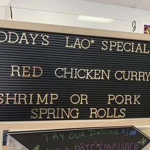 a sign that says today&apos;s lao specials red chicken curry shrimp or pork spring rolls