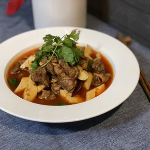 a bowl of stew and chopsticks