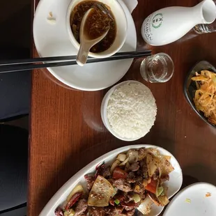 a bowl of rice, a bowl of beef, and a bowl of soup on a table