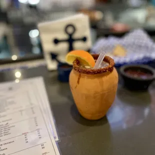 a cocktail in a wooden cup