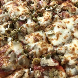 a pizza with pepperoni, olives, and cheese