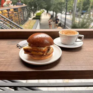 a cup of coffee and a sandwich on a table