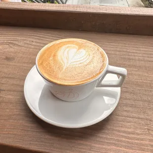 a cup of cappuccino on a wooden table