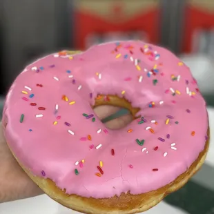 a pink frosted donut with sprinkles