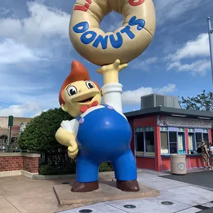 a statue of a man holding a donut