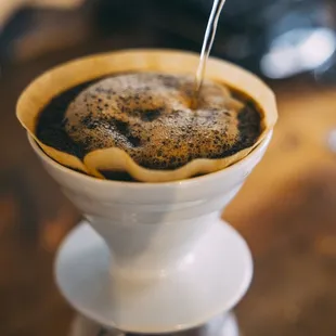 a coffee being poured into a cup