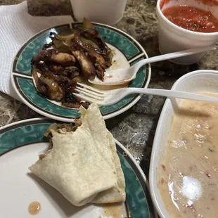 Half eaten chicken fajitas :) I like to get the dinner portion to have some leftovers! Salsa and queso I mix it a little. Yum!!!