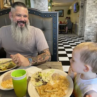 a man with a beard and a child eating