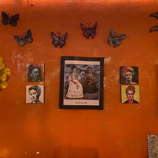 a living room with orange walls and butterflies on the wall