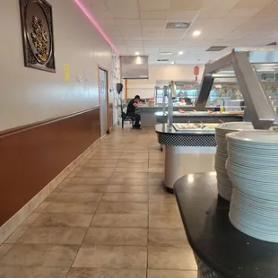 Sushi guy eating by the food while all of the sushi is empty and cold and not fresh.