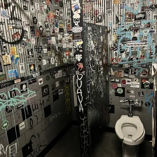 a toilet with graffiti on the walls