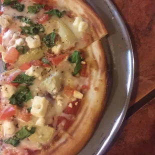 Gluten free dough with tomato, artichoke hearts, spinach, and feta