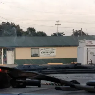 ows a view of a bar - b - que from the windshield of a car