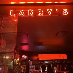 a neon sign above a bar