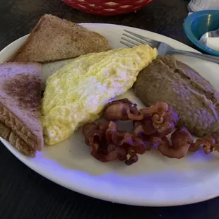 Sausage omelet that comes with bread, bacon, and beans.