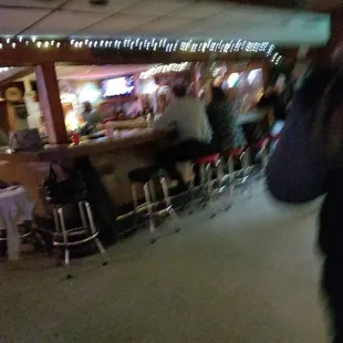 a blurry image of a man walking through a restaurant