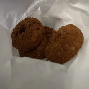 three cookies in a white paper bag