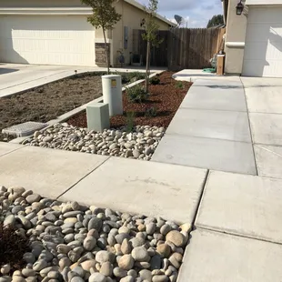 Grass was pulled out, concrete was added along with cobblestone, a tree, new plants, and lighting.