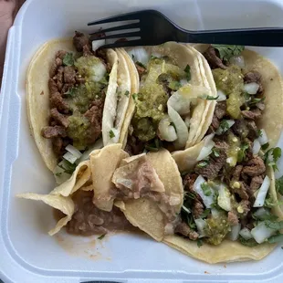 Carne Asada Tacos with chile verde. Flavorful beans and chips on the side.