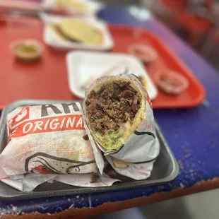 a burrito and chips on a tray