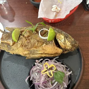 Pescado Frito Entero-Whole mojarra seasoned with garlic, salt, pepper floured and fried. Served with fried yucca, rice and onion sarsa.