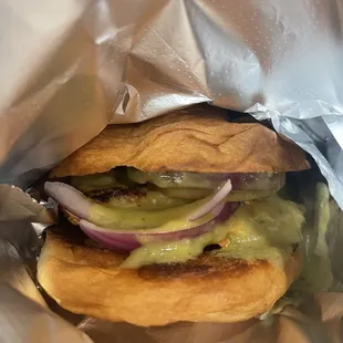 a sandwich wrapped in aluminum foil