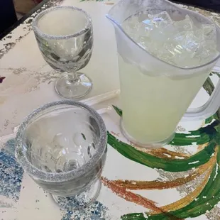 a pitcher of lemonade and two glasses of lemonade