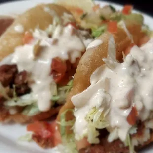 two tacos on a plate with sauce