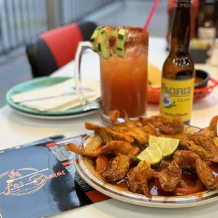 a plate of chicken wings and a bottle of beer