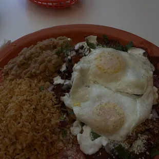 Chilaquiles with sunny side up eggs with rice and beans