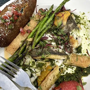 Pan seared Mediterranean Branzino with chimmichuri, masa biscuit, micro herb salad and chili oil.