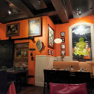 a dining room with orange walls
