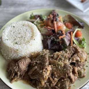 Bistec encebollado, arroz con habichuelas y ensalada.