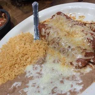 Red chicken enchiladas with rice and beans