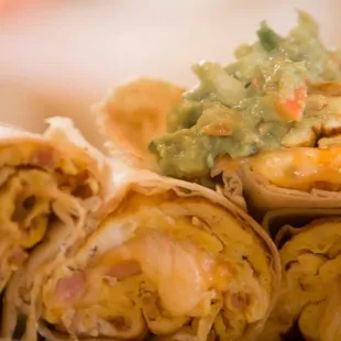 a plate of burritos with guacamole