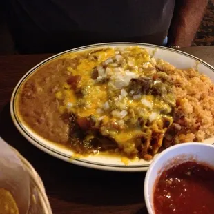 Tamale and Cheese Enchilada with rice and beans covered in Green Chile